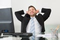 Relaxed businessman with hands behind head at desk Royalty Free Stock Photo