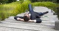 Relaxed businessman lying on wooden bridge in green park Royalty Free Stock Photo