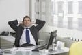 Relaxed Businessman Sitting At Desk In Office Royalty Free Stock Photo