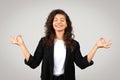 Relaxed businesswoman doing yoga gesture and meditating