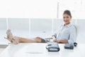 Relaxed businesswoman sitting with legs on desk in office Royalty Free Stock Photo