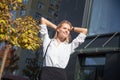 Relaxed calm happy woman resting taking healthy break holding hands behind head breathing fresh air against of office Royalty Free Stock Photo