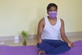 Relaxed carefree man in medical mask meditates sitting at home on quarantine. Healthy lifestyle concept