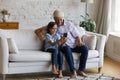 Relaxed carefree old grandfather and small kid using cellphone. Royalty Free Stock Photo
