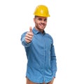 Relaxed casual engineer with protection helmet makes thumbs up s