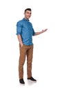 Relaxed casual man standing and presenting to side Royalty Free Stock Photo