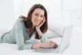 Relaxed casual smiling woman using laptop in bed Royalty Free Stock Photo