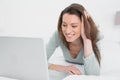 Relaxed casual smiling woman using laptop in bed Royalty Free Stock Photo