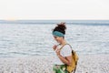 Relaxed caucasian woman with yellow backpack walking by the beach during sunset. summer time. daydreaming. Outdoors lifestyle Royalty Free Stock Photo