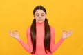 relaxed child with long hair meditating on yellow background, yoga