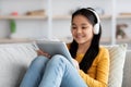 Relaxed chinese child resting on couch with digital tablet Royalty Free Stock Photo