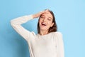 Relaxed and comfortable. Portrait of young beautiful girl in casual clothes posing over blue studio background. Concept Royalty Free Stock Photo