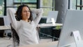 Relaxed contented young woman sitting at workplace enjoying finished work happy calm businesswoman leaning back in chair Royalty Free Stock Photo