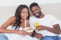 Relaxed couple in bed together eating cereal Royalty Free Stock Photo