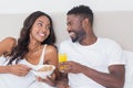 Relaxed couple in bed together eating cereal Royalty Free Stock Photo
