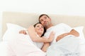 Relaxed couple lying together on their bed