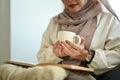 Relaxed elderly woman sitting on armchair drinking hot tea and looking away Royalty Free Stock Photo