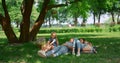 Relaxed family lying on green grass on picnic. Tranquil people rest in park. Royalty Free Stock Photo