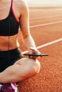 Relaxed female athlete sitting on race track