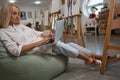 Relaxed female person using her laptop in workshop