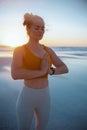 Relaxed fitness woman jogger at beach at sundown doing yoga