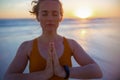 Relaxed fitness woman jogger rejoicing at beach at sundown