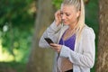 Relaxed fitness woman texting sms on smartphone during a workout break. Royalty Free Stock Photo