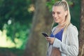 Relaxed fitness woman texting sms on smartphone during a workout break. Royalty Free Stock Photo