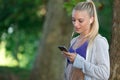 Relaxed fitness woman texting sms on smartphone during a workout break. Royalty Free Stock Photo