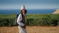 Relaxed girl admiring landscape at ocean cliff. Young tourist walking pathway