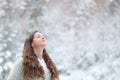 Relaxed girl breathing fresh air enjoying snow in winter