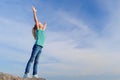 Relaxed girl breathing fresh air raising arms over blue sky at summer. Dreaming, freedom and traveling concept Royalty Free Stock Photo