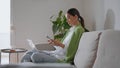 Relaxed girl checking cellphone working home sofa alone. Woman learning online