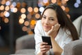 Relaxed girl looking at camera holding a phone