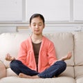 Relaxed girl sitting cross-legged meditating