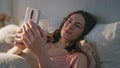 Relaxed girl videocalling home in morning closeup. Pretty calm female rest bed Royalty Free Stock Photo