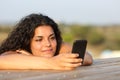 Relaxed girl watching social media in smart phone