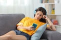 Relaxed girl in yellow listening to music at home