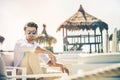 Relaxed handsome man sitting on white chairs during summer Royalty Free Stock Photo