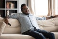 Relaxed african man hold remote control watching tv at home Royalty Free Stock Photo