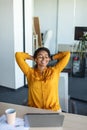 Relaxed happy businesswoman holding hands behind head, sitting at desk and resting, working in modern office, cropped Royalty Free Stock Photo