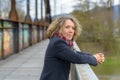 Relaxed happy woman leaning on a bridge parapet