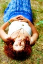 Relaxed hippie girl lying on meadow on bright midsommer day.