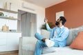 Relaxed Indian Man Turning On Air Conditioner Sitting At Home