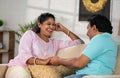 Relaxed indian middle aged couple talking spending time by talking each other on sofa at home - concept of communication