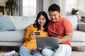 Relaxed japanese spouses using notebook and credit card
