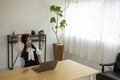 A relaxed Japanese woman by remote work in the small office Royalty Free Stock Photo