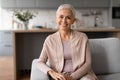 Relaxed and joyful senior woman sitting on sofa at home Royalty Free Stock Photo