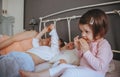 Relaxed little girl eating cookies over the bed Royalty Free Stock Photo