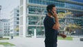 Relaxed man calling mobile phone near office. Casual guy having business call